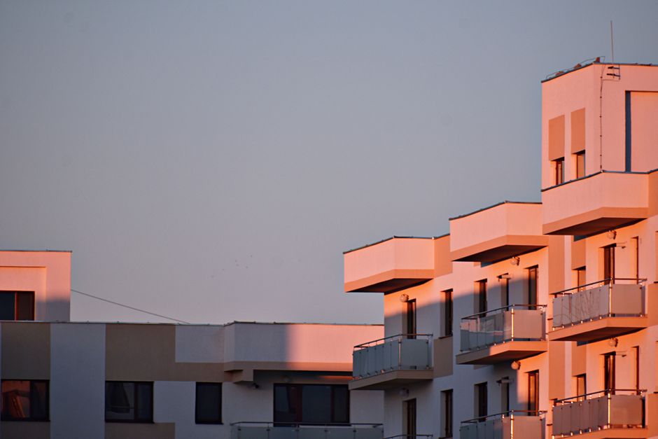 Modern apartment building with balconies bathed in sunset light.